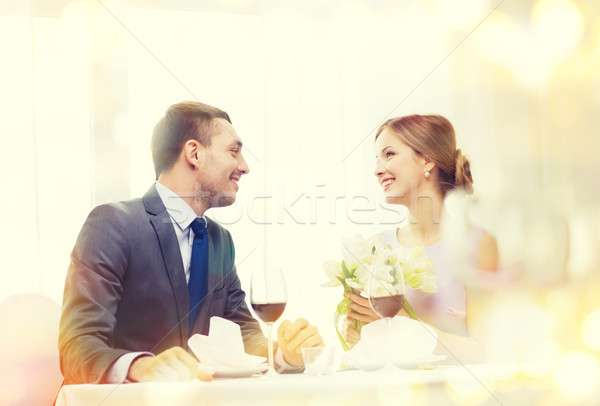 smiling man giving flower bouquet at restaurant Stock photo © dolgachov