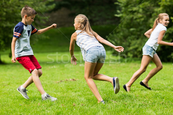 group of happy kids or friends playing outdoors Stock photo © dolgachov