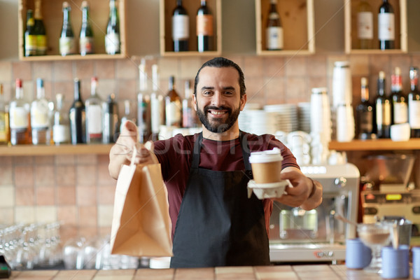 man or waiter with coffee and paper bag at bar Stock photo © dolgachov