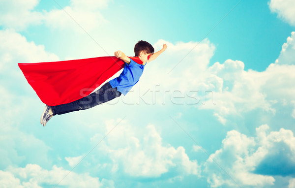 Stock photo: boy in red superhero cape and mask flying over sky