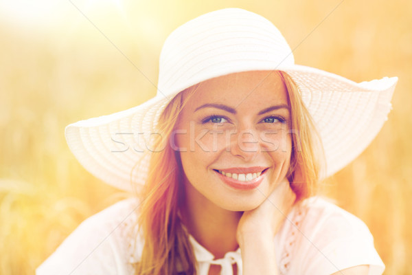 Stock photo: close up of happy woman in sun hat on cereal field