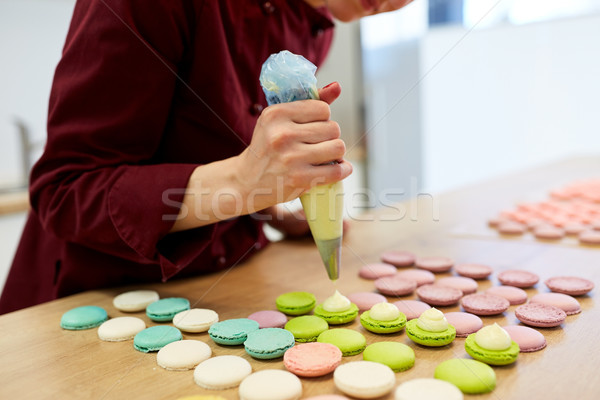 chef with injector squeezing filling to macarons Stock photo © dolgachov
