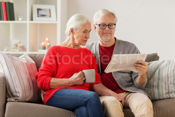 Stock photo: happy senior couple reading newspaper at christmas