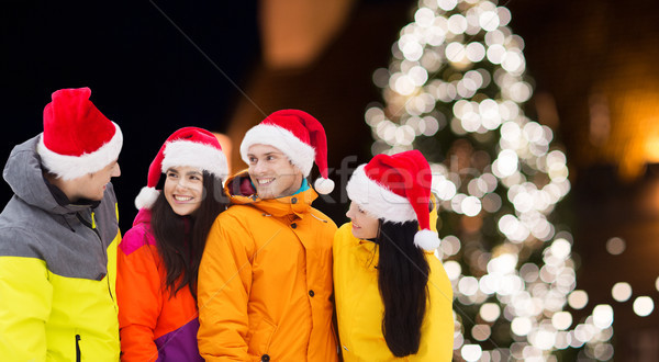 friends in santa hats and ski suits at christmas Stock photo © dolgachov