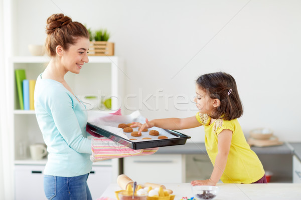 happy mother and daughter baking cookies at home Stock photo © dolgachov