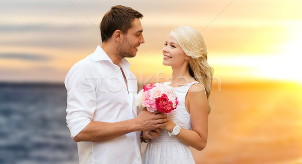 happy couple with flowers over sea background Stock photo © dolgachov