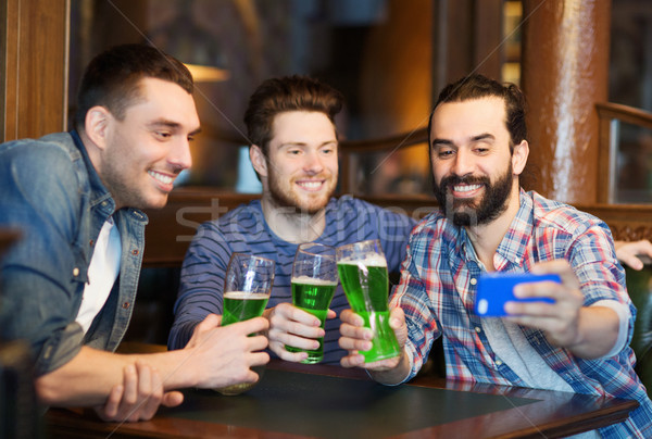 friends taking selfie with green beer at pub Stock photo © dolgachov