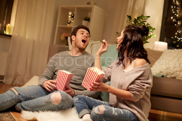 happy couple eating popcorn at home Stock photo © dolgachov
