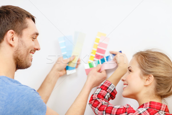 smiling couple looking at color samples at home Stock photo © dolgachov