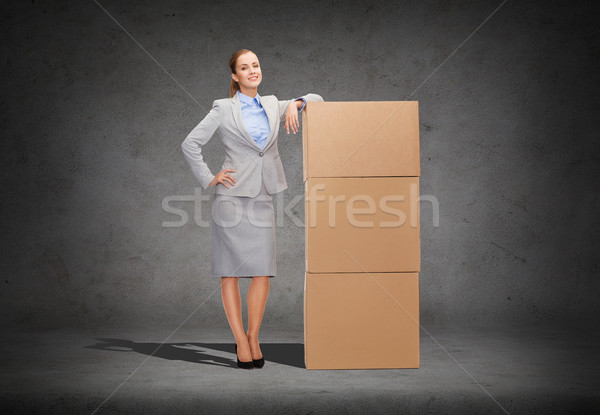 smiling businesswoman with cardboard boxes Stock photo © dolgachov