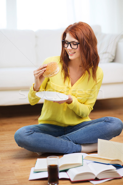 student eating hamburger and doing homework Stock photo © dolgachov