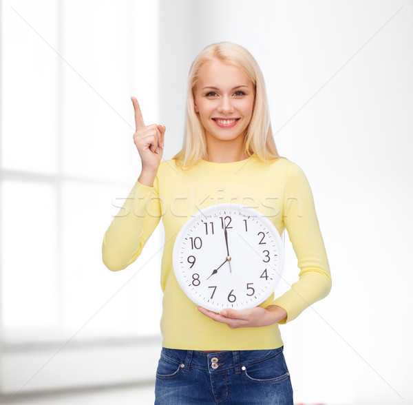 student with wall clock and finger up Stock photo © dolgachov