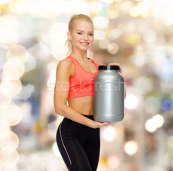 smiling sporty woman with jar of protein Stock photo © dolgachov