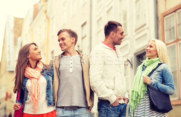 group of smiling friends walking in the city Stock photo © dolgachov