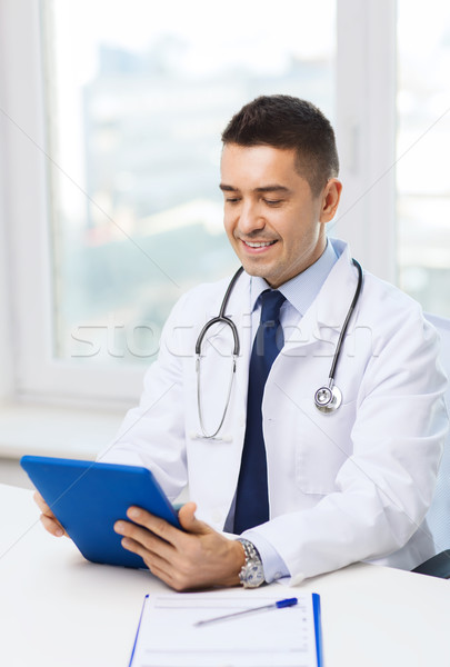 smiling male doctor in white coat with tablet pc Stock photo © dolgachov