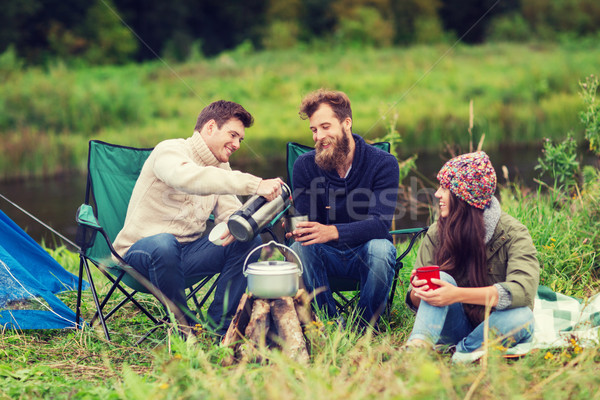 Groupe souriant touristes cuisson alimentaire camping [[stock_photo]] © dolgachov