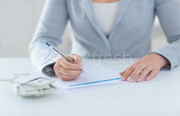 close up of hands with money filling tax form Stock photo © dolgachov
