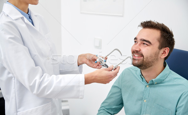 optician with trial frame and patient at clinic Stock photo © dolgachov