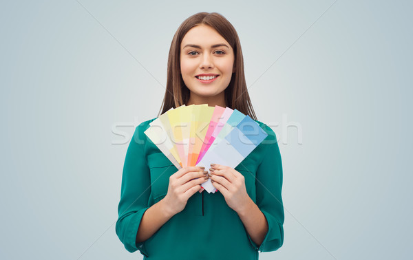 smiling young woman with color swatches Stock photo © dolgachov