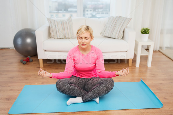 happy woman stretching leg on mat at home Stock photo © dolgachov