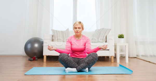 happy woman stretching leg on mat at home Stock photo © dolgachov