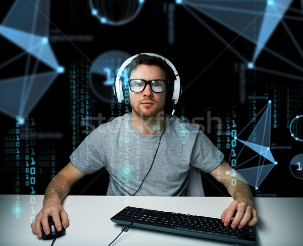 man in headset hacking computer or programming Stock photo © dolgachov