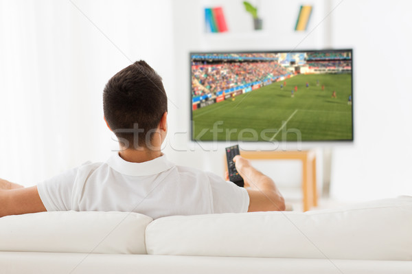man watching football or soccer game on tv at home Stock photo © dolgachov