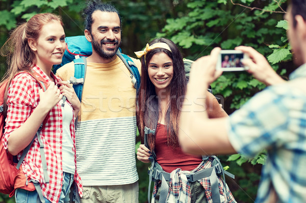 friends with backpack photographing by smartphone Stock photo © dolgachov