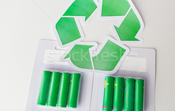Stock photo: close up of batteries and green recycling symbol