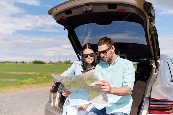 Stock photo: happy man and woman with road map at hatchback car