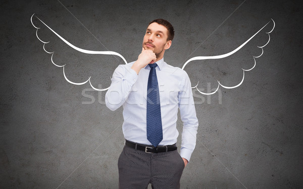 businessman with angel wings over gray Stock photo © dolgachov