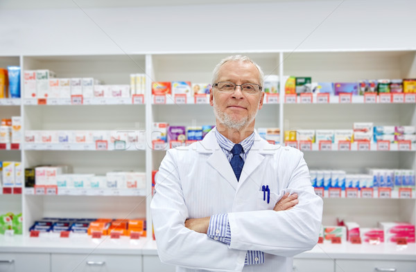 senior male pharmacist in white coat at drugstore Stock photo © dolgachov