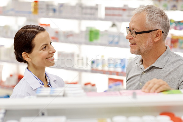 happy pharmacist talking to senior man at pharmacy Stock photo © dolgachov