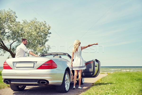 happy man and woman near cabriolet car at sea Stock photo © dolgachov
