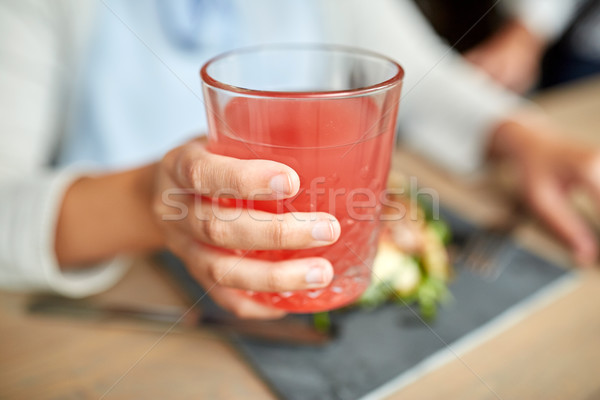 hand with glass of juice at restaurant Stock photo © dolgachov