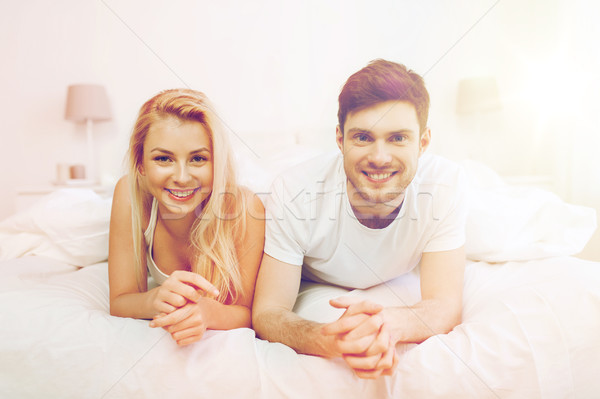 Stock photo: happy couple lying in bed at home