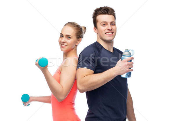 sportive man and woman with dumbbell and water Stock photo © dolgachov