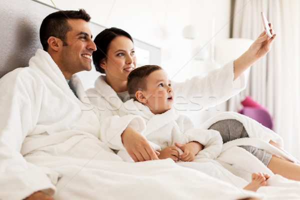 Stockfoto: Gelukkig · gezin · smartphone · bed · hotelkamer · mensen · familie