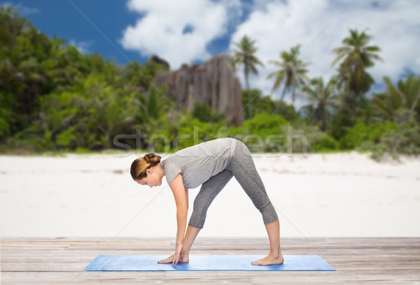 woman making yoga intense stretch pose on beach Stock photo © dolgachov