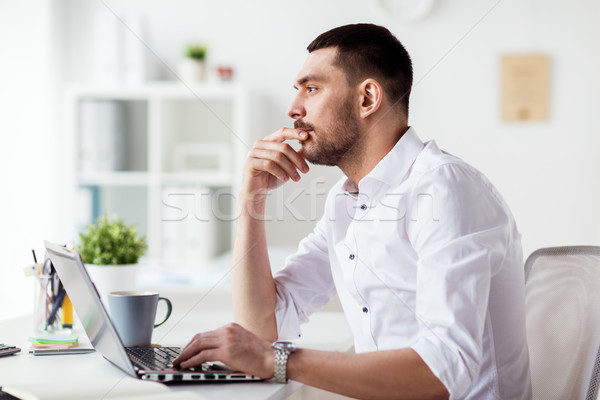 businessman with laptop thinking at office Stock photo © dolgachov