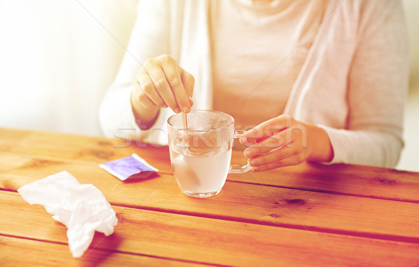 woman stirring medication in cup with spoon Stock photo © dolgachov