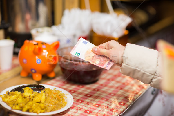 hand with money paying food at street market Stock photo © dolgachov