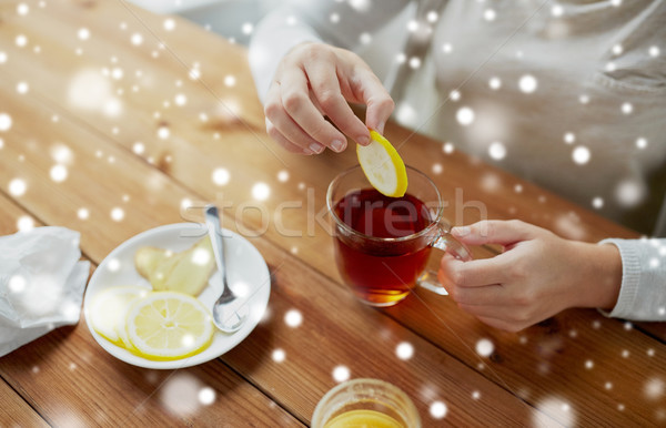 close up of woman adding honey to tea with lemon Stock photo © dolgachov