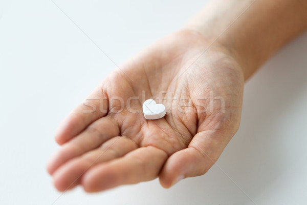 close up of hand holding medicine heart pill Stock photo © dolgachov