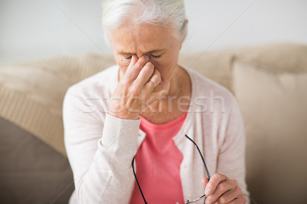 senior woman with glasses having headache at home Stock photo © dolgachov