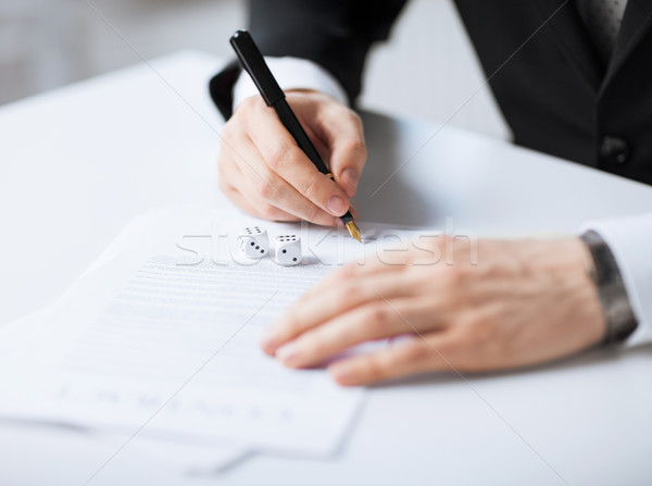man hands with gambling dices signing contract Stock photo © dolgachov