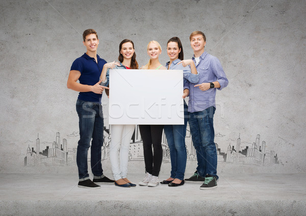 group of smiling students with white blank board Stock photo © dolgachov