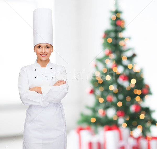 smiling female chef  with crossed hands Stock photo © dolgachov