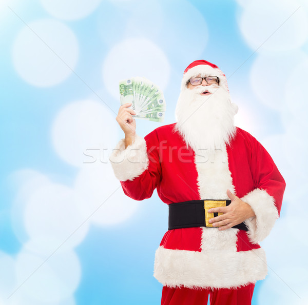 man in costume of santa claus with euro money Stock photo © dolgachov