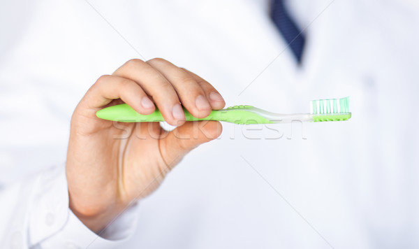 dentist or stomatologist holding toothbrush Stock photo © dolgachov